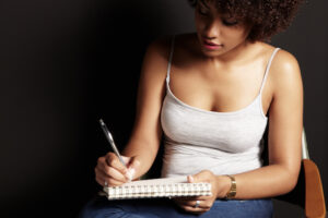 african woman is writing in a dark room